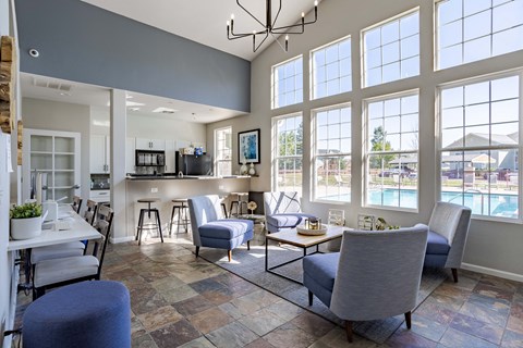a living room with couches and chairs and a kitchen with a pool